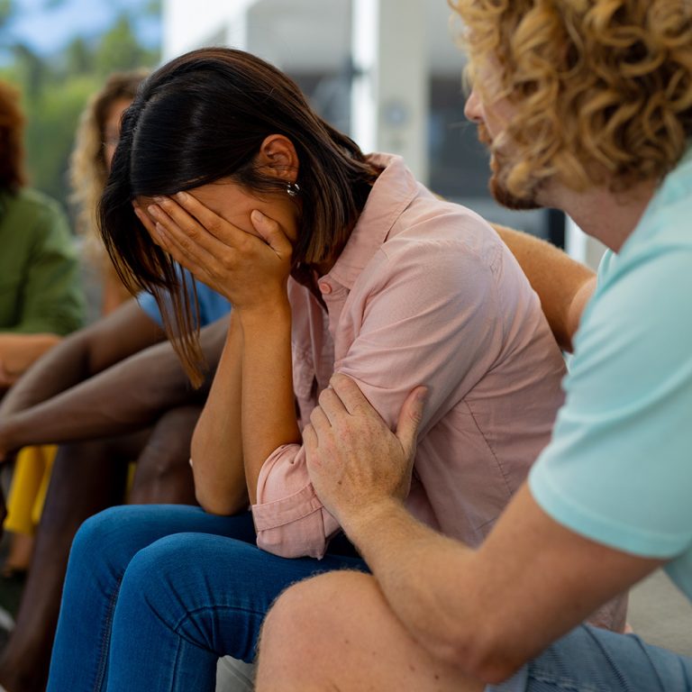 Group of diverse people sitting on sofa, talking and crying in group therapy session. Lifestyle, friendship and support, togetherness, unaltered.