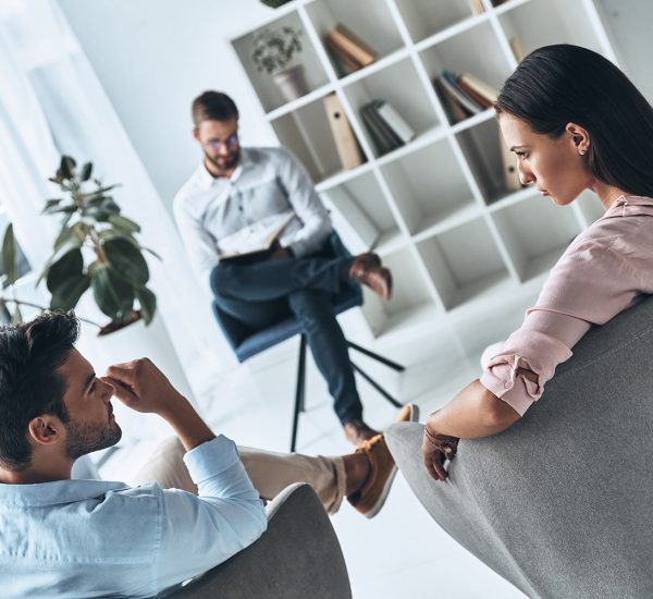 Helping others. Young married couple talking while sitting on the therapy session with psychologist